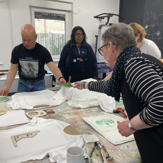 Demonstration of printing for Wild Roots Nature Fest with 3 volunteers pictured around a table.